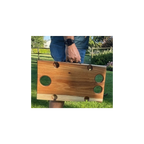 Person holding a wooden wine table outdoors on a grassy area.