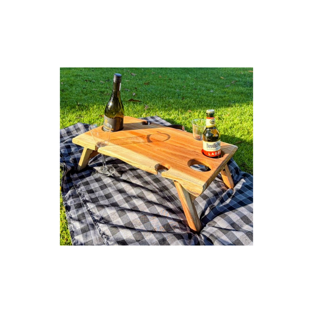 Wooden wine table with bottles on a grassy background