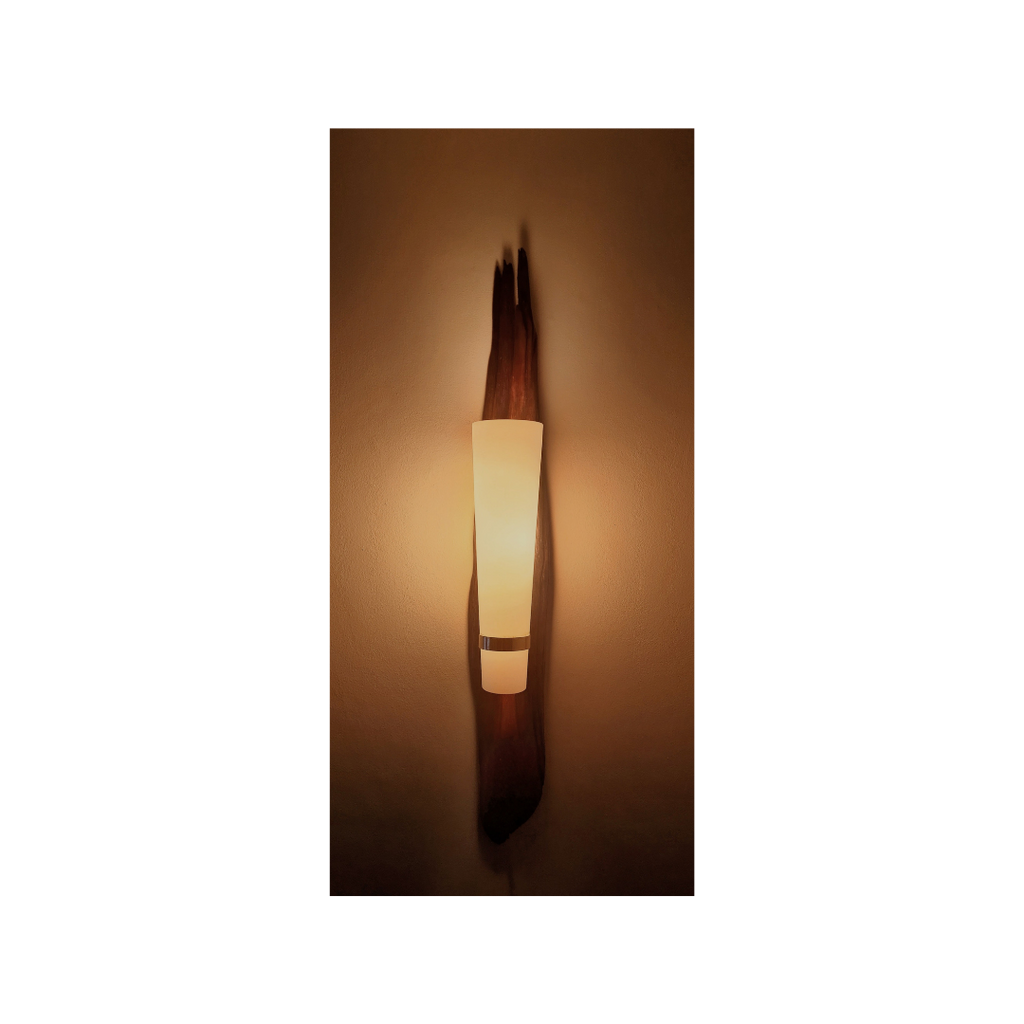 Wall-mounted light fixture casting a warm glow on a wall.