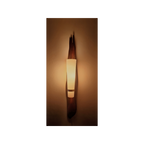 Wall-mounted light fixture casting a warm glow on a wall.