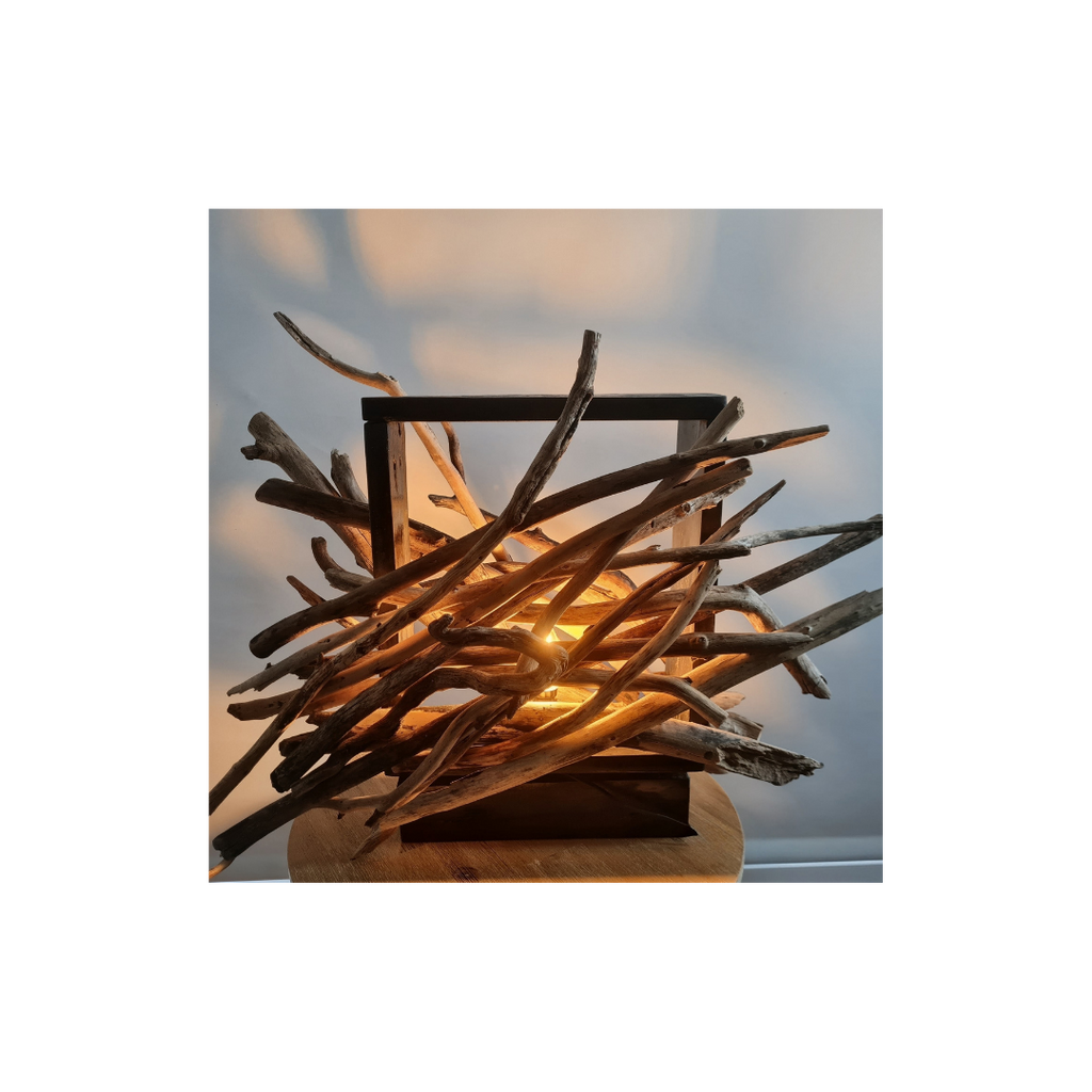 Lamp made of intertwined branches with a warm glow on a blurred background