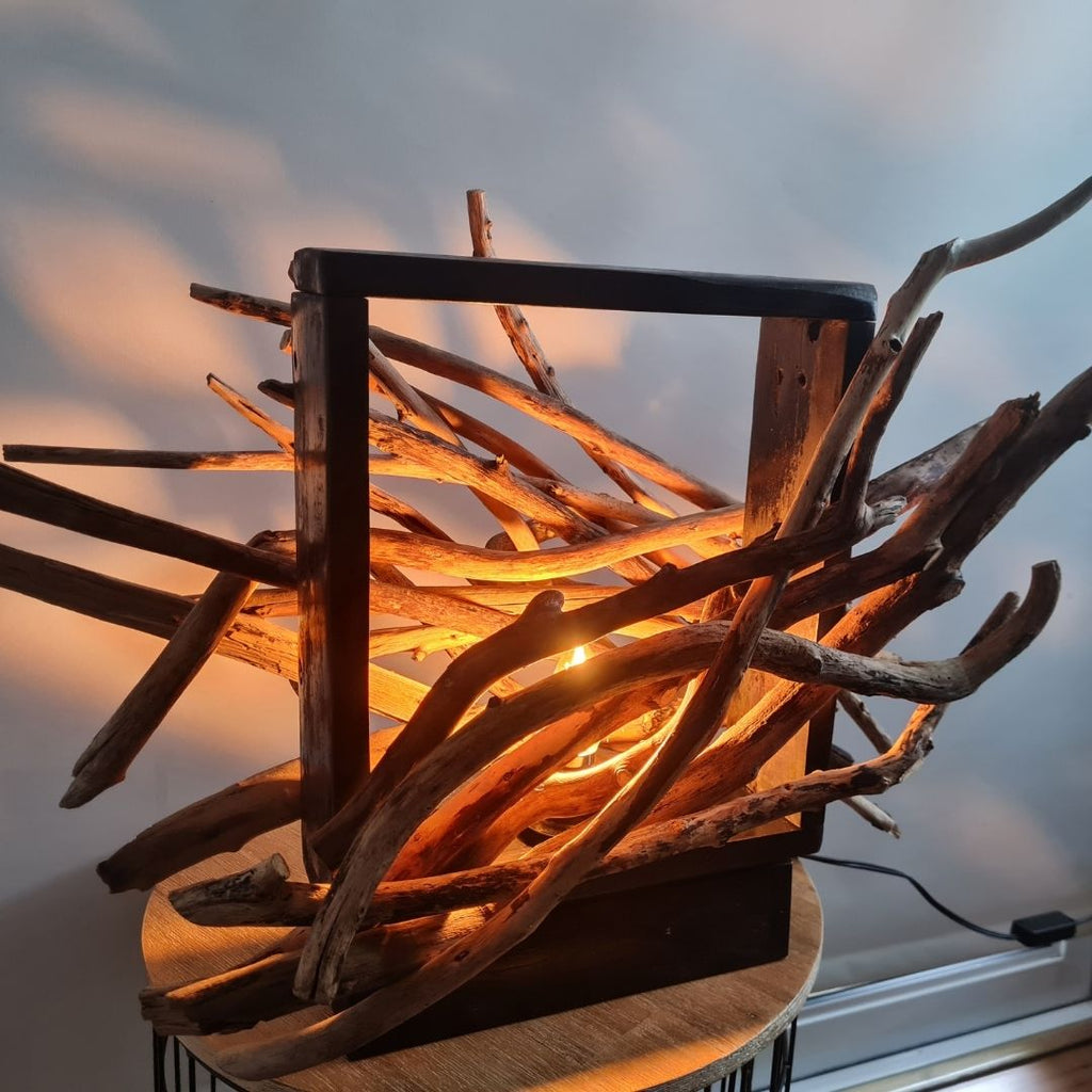 Driftwood lamp with a warm glow on a white background