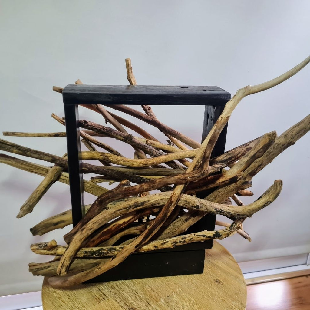 Driftwood lamp with a warm glow on a white background