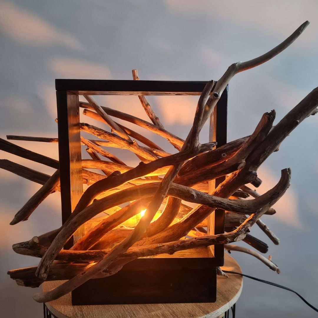 Driftwood lamp with a warm glow on a white background