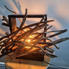 Driftwood lamp with a warm glow on a white background