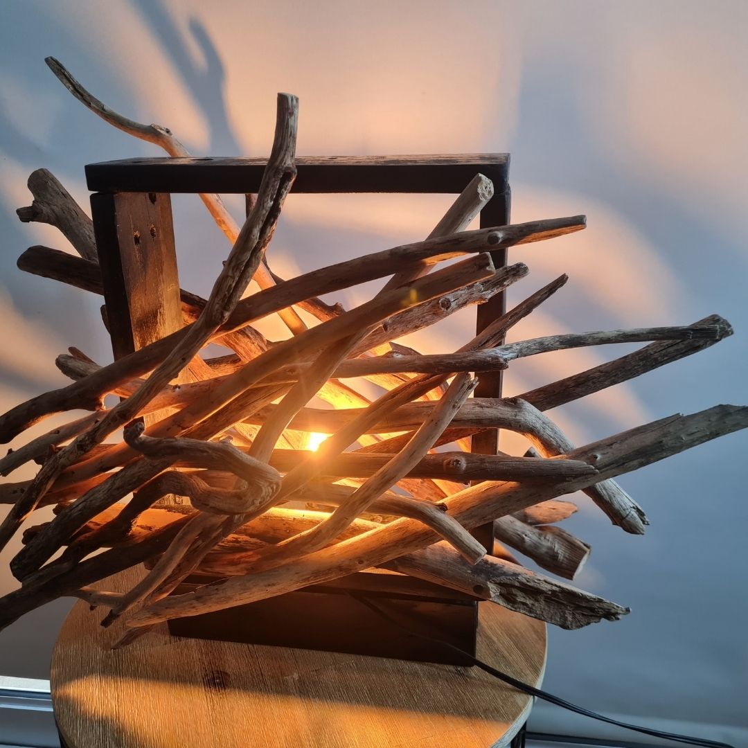 Driftwood lamp with a warm glow on a white background