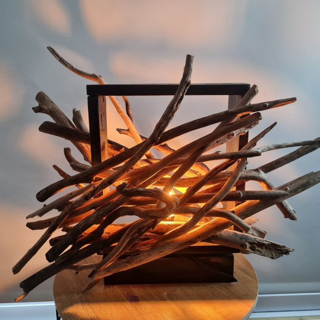 Driftwood lamp with a warm glow on a white background