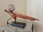 Wooden lamp with a glass shade on a metallic surface