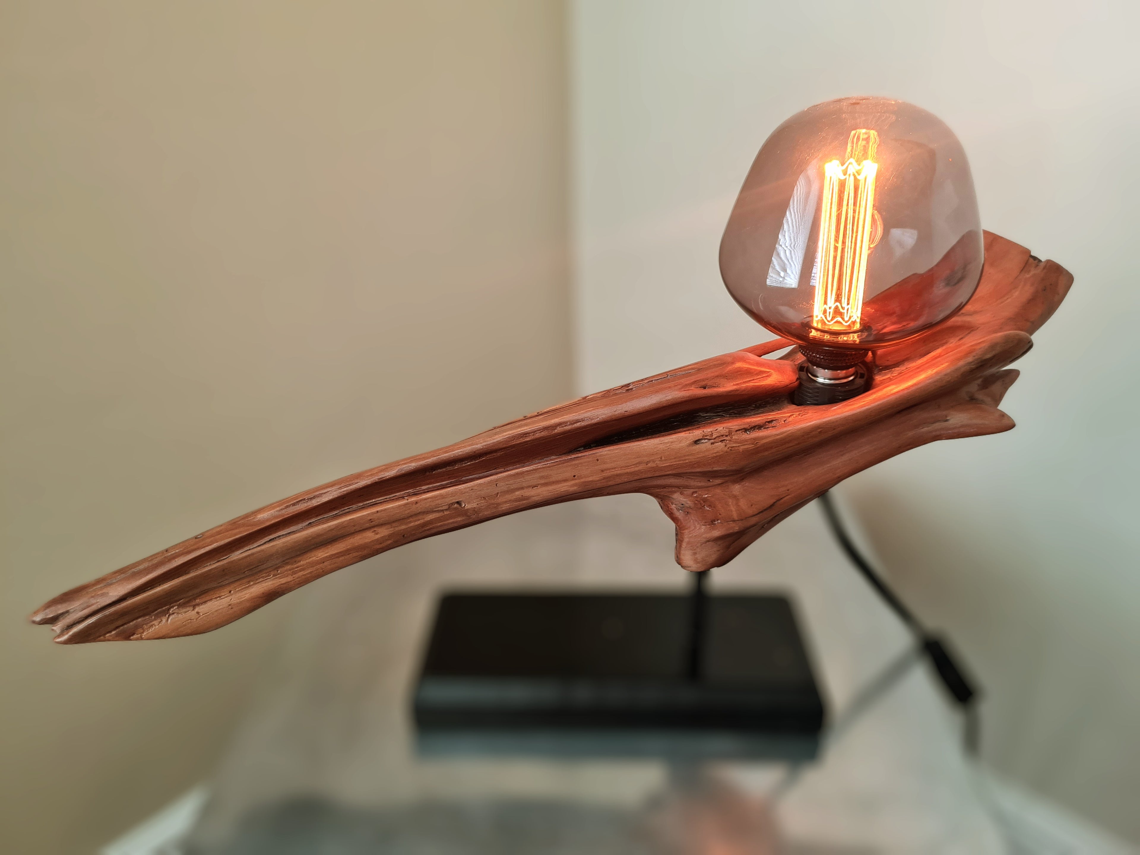 Wooden lamp with a glowing light bulb on a neutral background